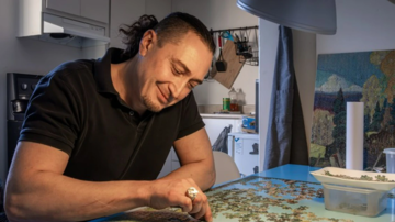 Rashid Gizitdinov travaille à un casse-tête dans son nouveau logement. Photo : Dave Sidaway /Montreal Gazette